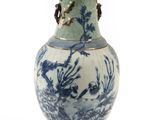 un vase bleu et blanc posé sur une surface blanche
