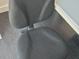 a grey office chair sitting in front of a computer desk