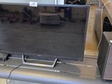 a television sitting on top of a table next to a speaker