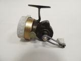 a close up of a fishing reel on a white surface