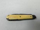 an image of a small knife with a yellow handle on a white surface