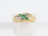 a close up of a gold ring with a green stone