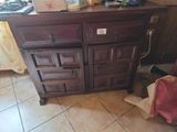 une armoire en bois sur laquelle sont posés de nombreux objets