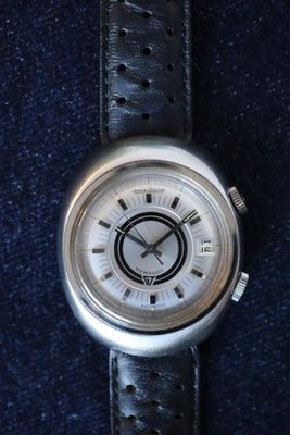 an image of a close up of a wrist watch on a blue surface