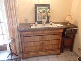 a picture of a dresser in a room with a picture on the wall