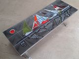 un banc en verre sur lequel sont peints des voiliers