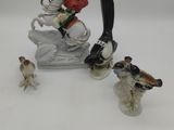 figurine of a man on a sled with birds on it