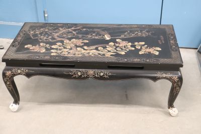une table basse noire ornée d'un motif floral