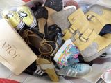 several pairs of shoes are packed in a bag on a bed