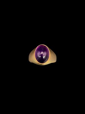 Gros plan sur une bague contenant une pierre violette