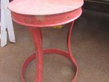 a small red table with a wooden top on the floor