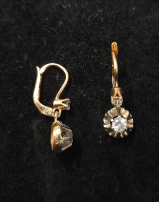une paire de boucles d'oreilles en or et diamants sur fond noir