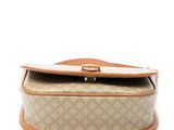 a close up of a beige and tan purse with a brown handle