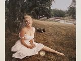 photo d'une femme en robe blanche assise dans l'herbe