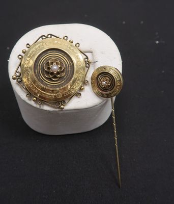 broche et épingles plaquées or sur un fond noir