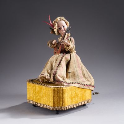 an image of a doll sitting on top of a yellow box