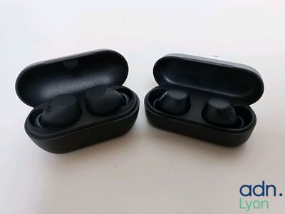 une photo montrant deux écouteurs noirs posés sur une table