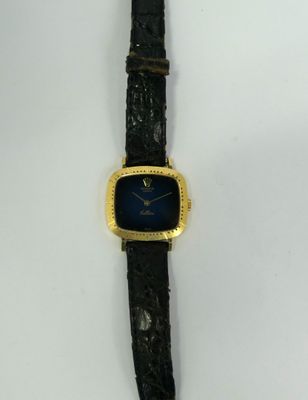 a close up of a watch on a white surface with a black strap