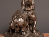 bronze statue of a dog and a cat sitting on a table