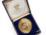 une image d'une médaille d'or dans un étui en velours