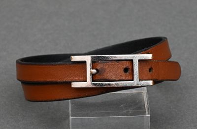 a close up of a brown leather belt with a silver buckle