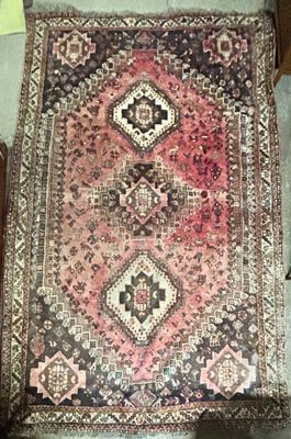 a rug on the floor next to a chair in a room