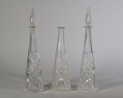 trois vases en verre posés l'un à côté de l'autre sur une table