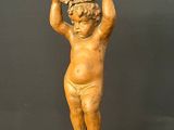 statue of a child holding a rock on his head