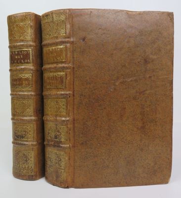 deux vieux livres posés l'un sur l'autre sur une surface blanche