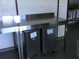 two trash cans sitting in the middle of a kitchen
