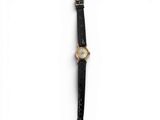 a close up of a watch on a white surface with a black strap