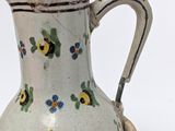 a small white vase with blue and yellow flowers on it