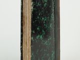 an open book with a green cover sitting on top of a white surface