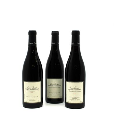 three bottles of wine sitting next to each other on a white surface