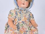 a doll that is wearing a dress and a hat