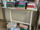 a table with many books on it in a room