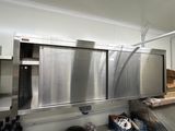 une cuisine avec des placards et un plan de travail en inox