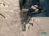 several pairs of jeans are wrapped in plastic bags on a bed