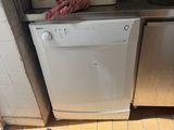a white dishwasher sitting in the corner of a kitchen