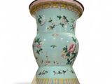 un vase bleu orné de fleurs roses sur fond blanc