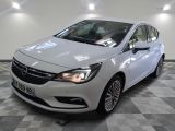 L'Opel blanche est garée sur un sol carrelé à damier.