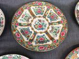 several plates and bowls are arranged on a table with a blue cloth