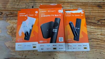 two boxes of remotes sitting on top of a wooden table