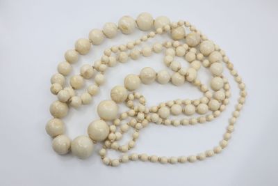 gros plan d'un collier de perles blanches sur une surface blanche
