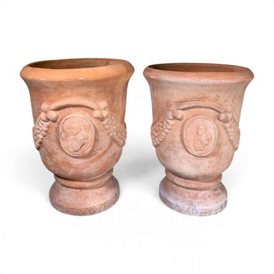 two vases sitting next to each other on a white surface