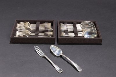 deux plateaux contenant des couverts, dont des cuillères, posés sur une table