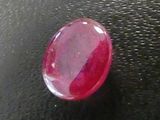 a close up of a red gemstone on a black surface