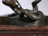 a bronze statue of a woman laying on a table