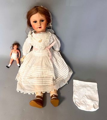 a doll that is sitting next to a cloth diaper
