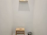 a small wooden bench in the corner of a small room